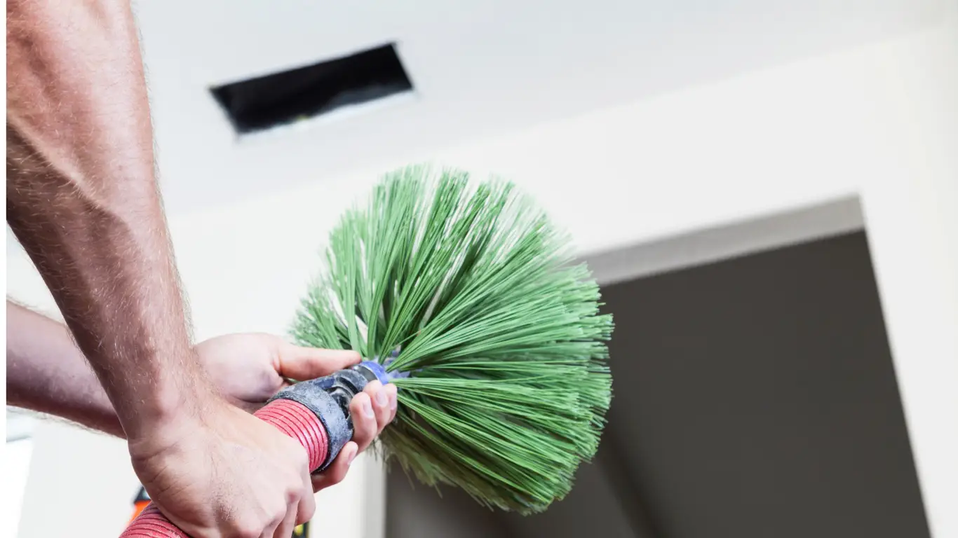 Air duct being cleaned with a rotary brush