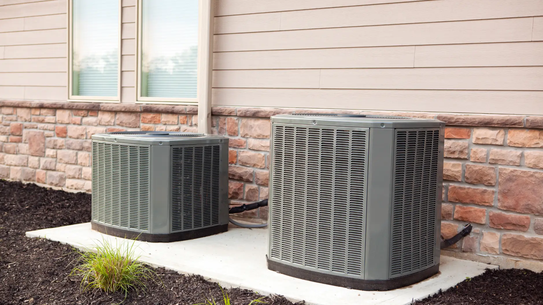 Outdoor air conditioning condenser unit beside a home
