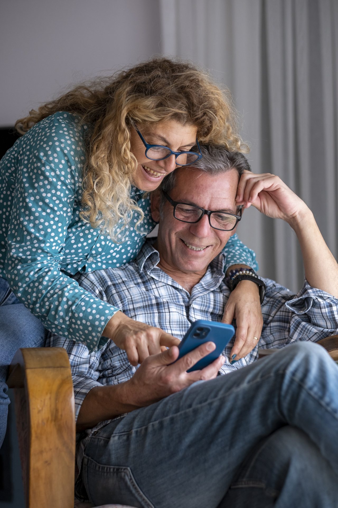 Couple looking at a phone together in their comfortable home