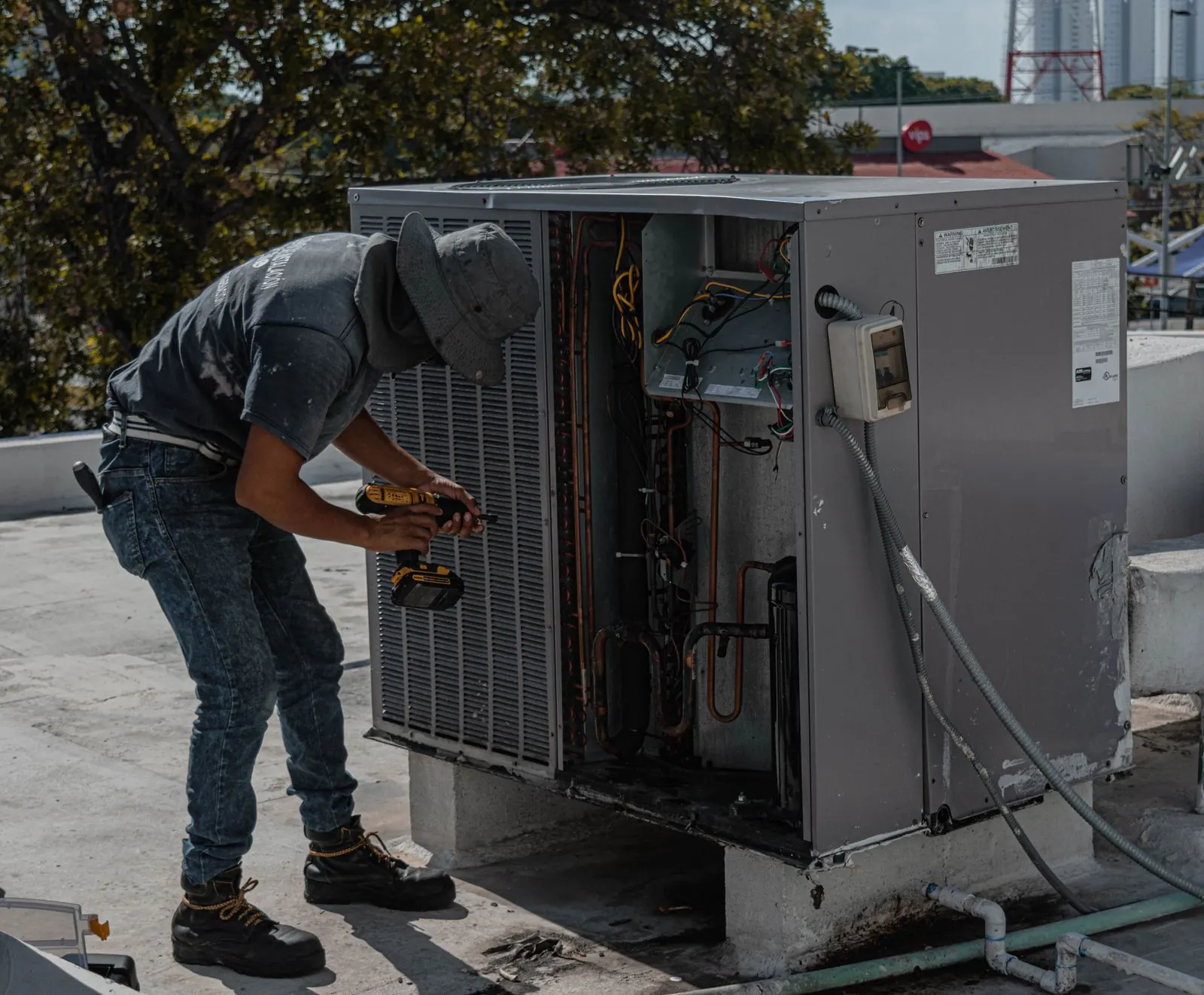 Technician servicing a rooftop unit on a small commercial building