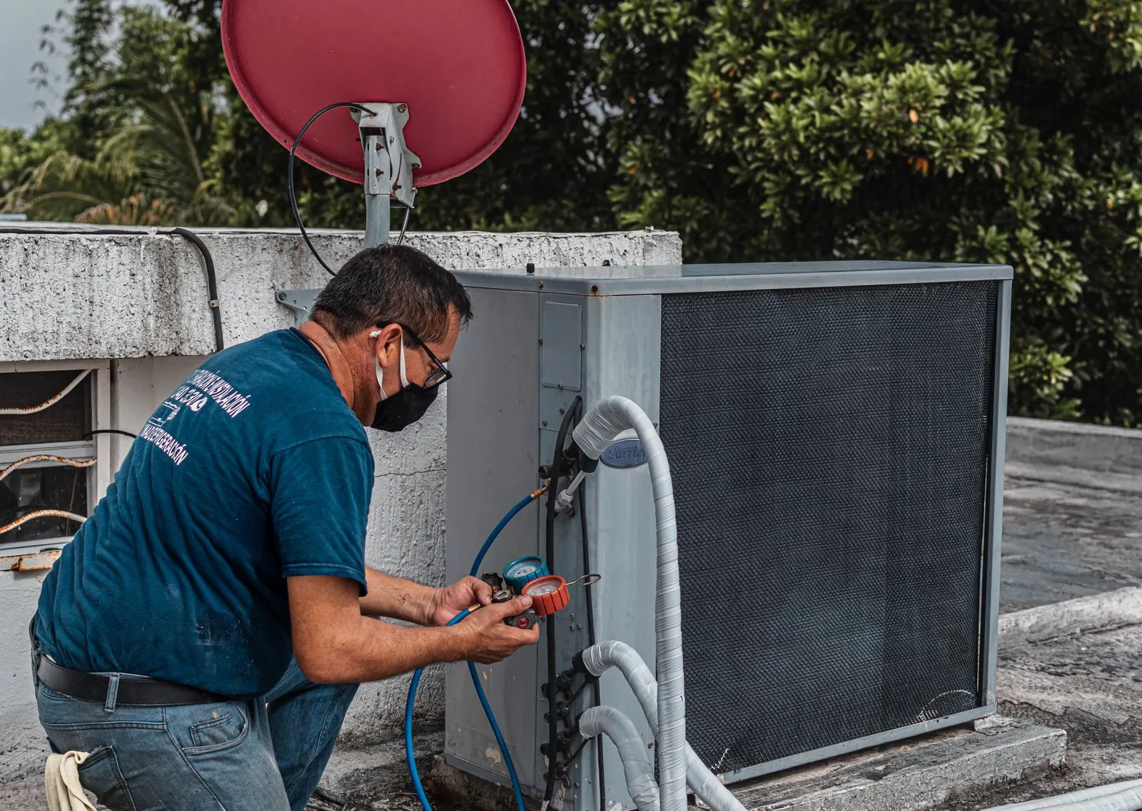 Technician servicing an outdoor AC unit on a summer evening