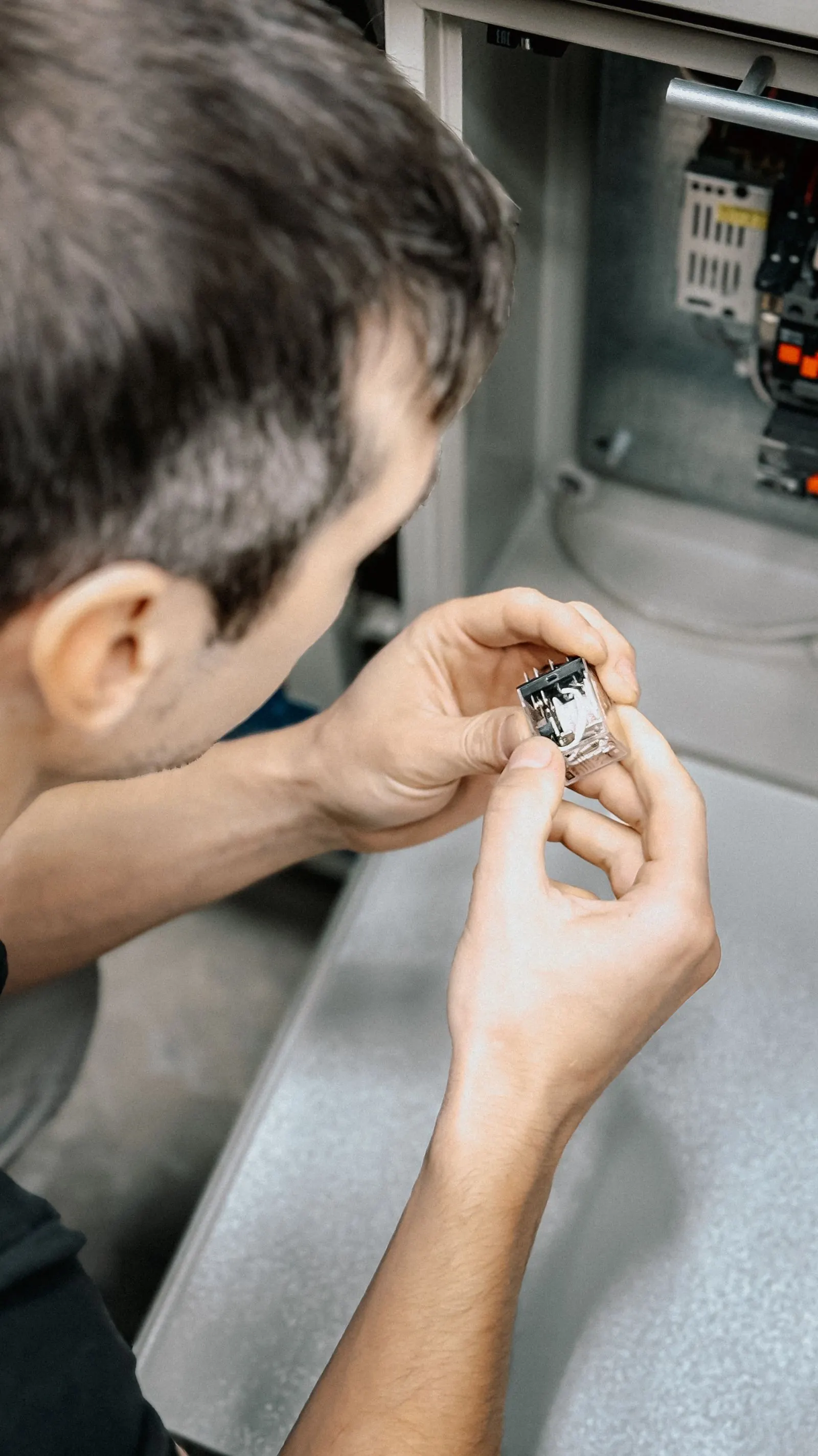 Technician holding a flame sensor removed from a furnace