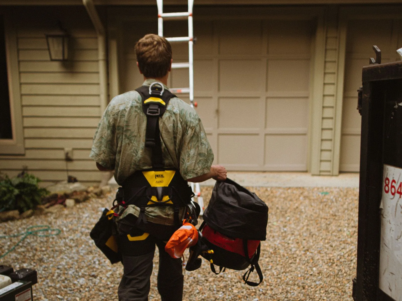 Technician arriving at a home at night with a tool bag